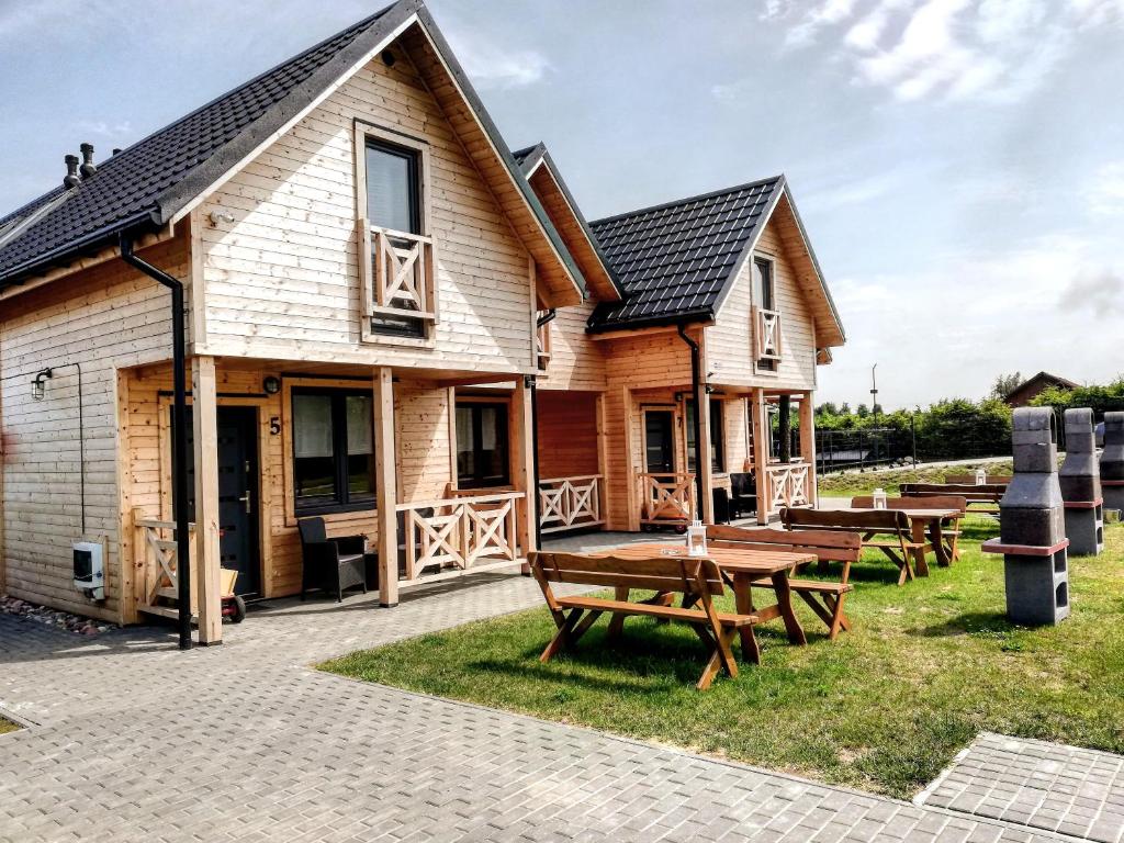 a house with picnic tables in front of it at Czarne Domki Chłopy in Chłopy