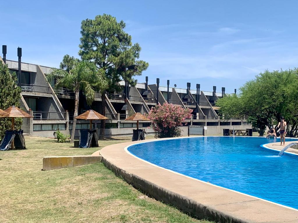 a swimming pool in front of a building at Apart Club San Pedro in San Pedro