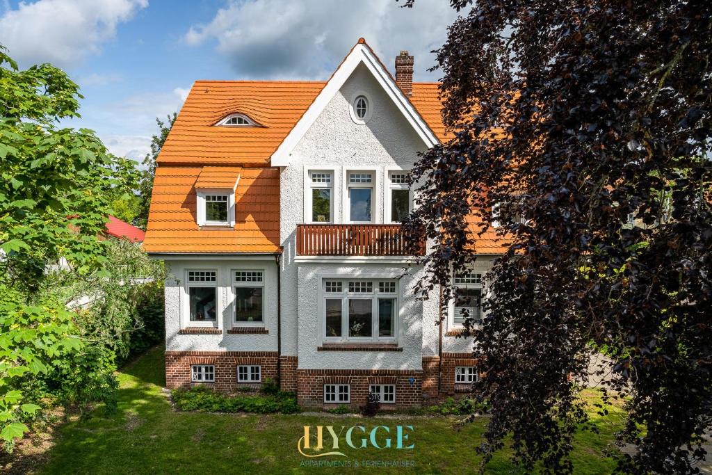 ein Bild eines Hauses mit orangefarbenem Dach in der Unterkunft Villa Hygge Kappeln - Ferienwohnungen in Kappeln