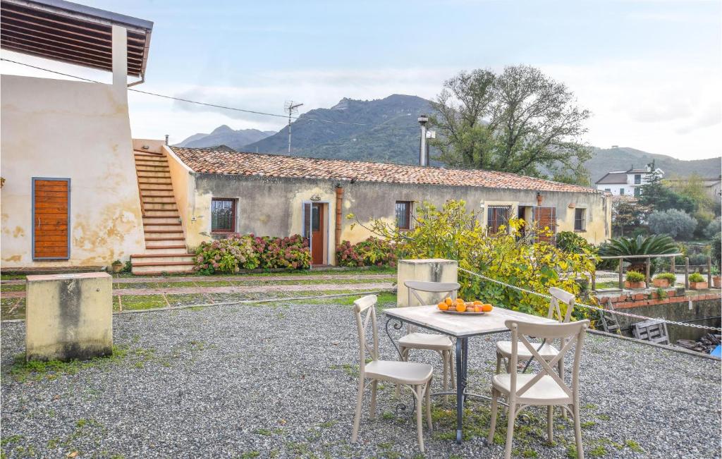 a table and chairs in front of a house at Gorgeous Home In Santa Lucia Del Mela in Santa Lucia del Mela