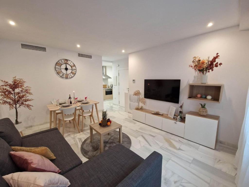 - un salon avec un canapé, une télévision et une table dans l'établissement Francisco Cano Apartment, à Fuengirola