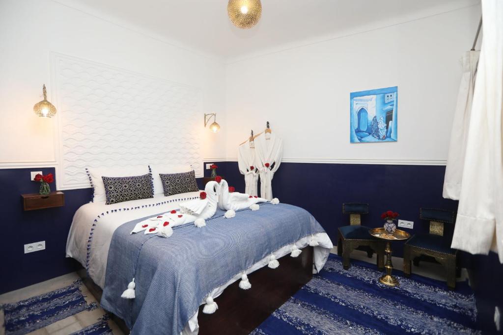 馬拉喀什的住宿－Riad Heklek，一间卧室配有两张蓝色和白色的床