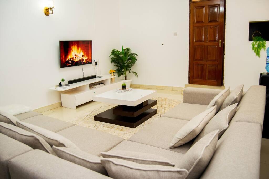 ein Wohnzimmer mit einem Sofa und einem TV in der Unterkunft Jenna stays in Nyeri