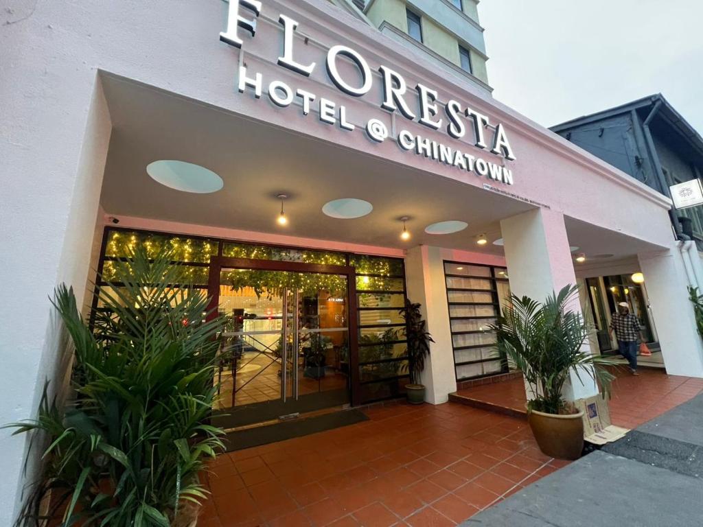 a hotel entrance with plants in front of a building at Floresta Hotel Chinatown in Kuala Lumpur