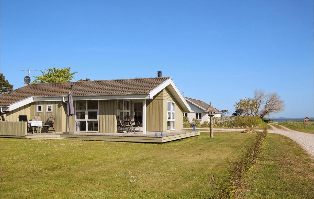 Amazing Home In Sams With House Sea View في Onsbjerg: منزل أصفر على جانب الطريق
