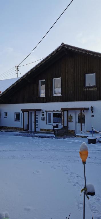 a building with snow on the ground in front of it at Linda in Ruderatshofen