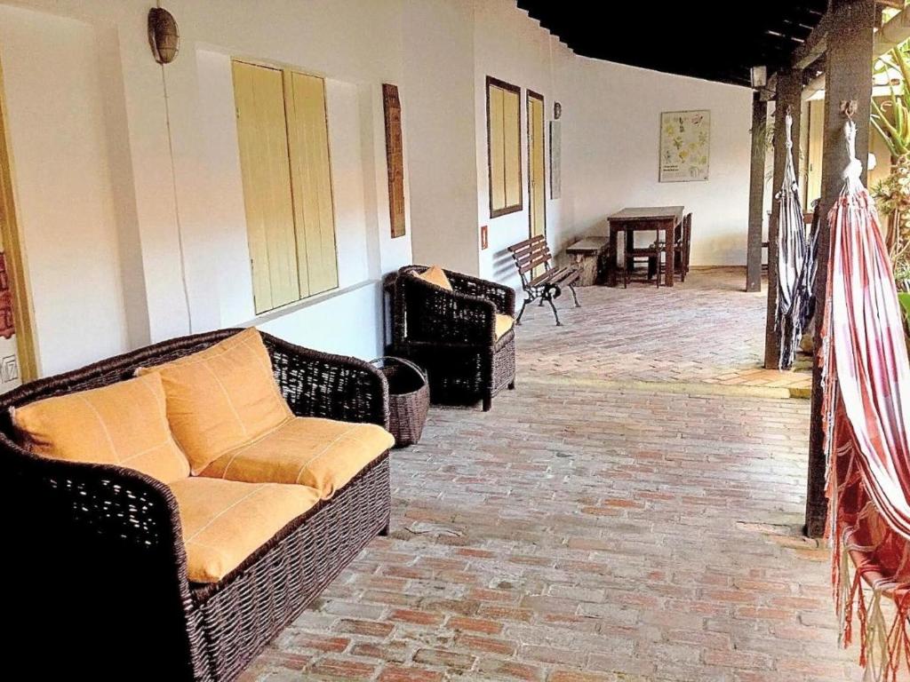 a living room with wicker couches and a table at Suítes a 50 metros da Rua das Pedras in Búzios