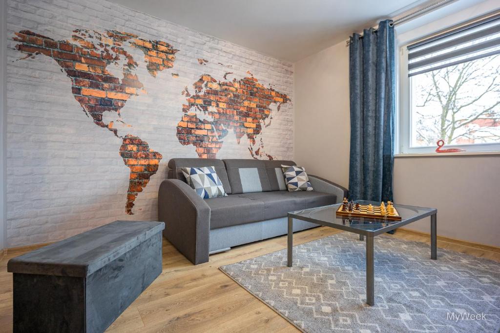a living room with a map of the world on the wall at Apartament Habel, MyWeek in Bystrzyca Kłodzka