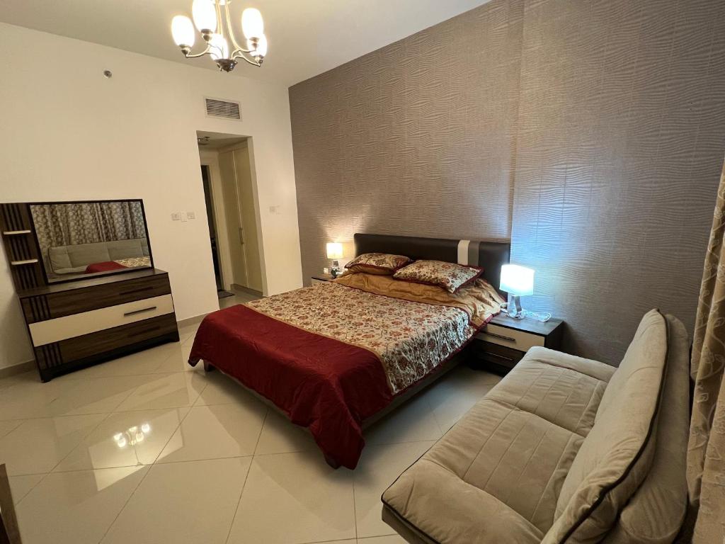 a bedroom with a bed and a couch in it at Large size one bedroom apartment with sea view in Abu Dhabi