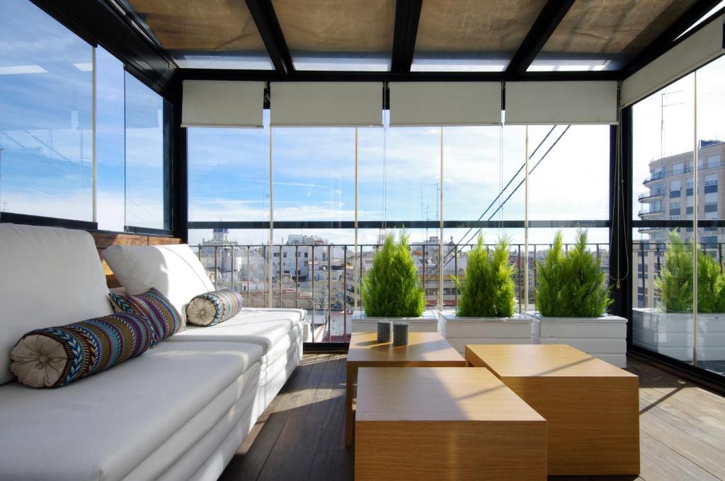 a living room with a white couch and large windows at Vivaldi Penthouse Ayuntamiento in Valencia