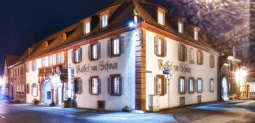 a large building is lit up at night at Gasthof zum Schwan in Sommerach