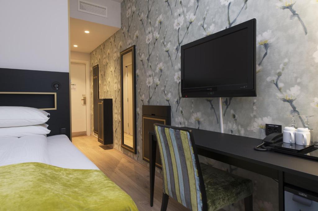 a hotel room with a bed and a flat screen tv at Thon Hotel Opera in Oslo