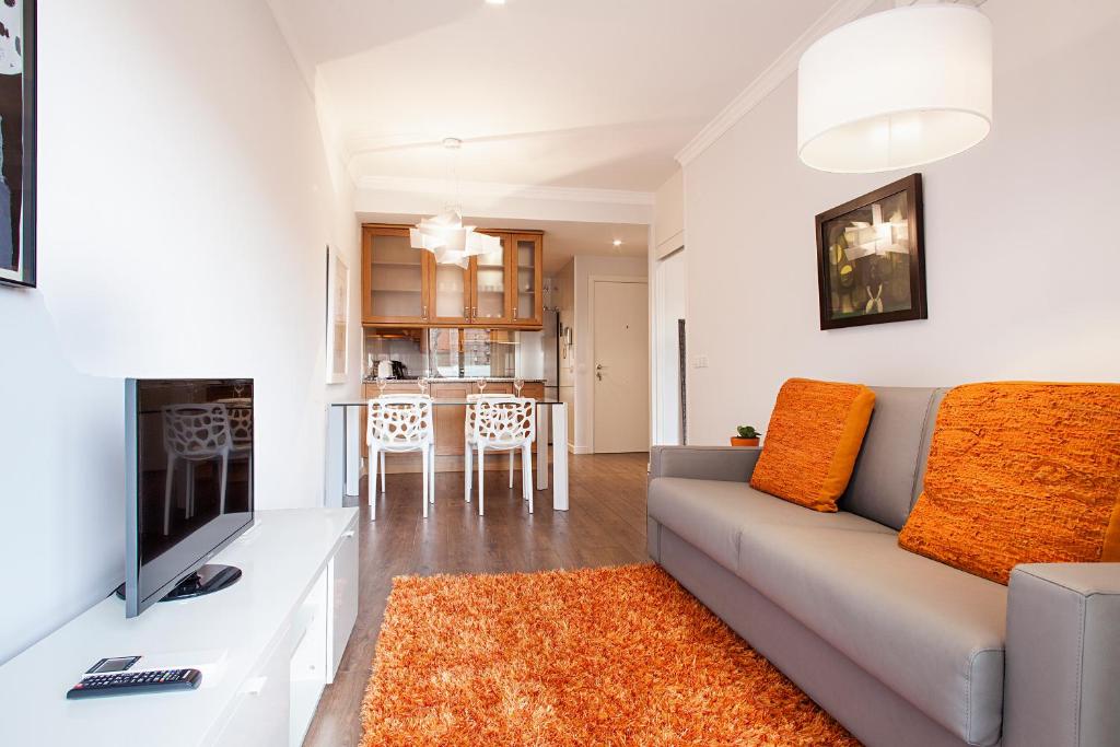 a living room with a couch and a television at Suites4days Provenza Apartment in Barcelona