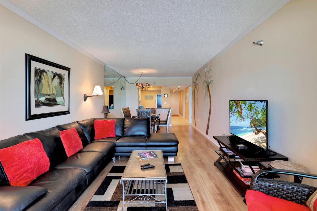 - un salon avec un canapé en cuir noir et des oreillers rouges dans l'établissement Villa Madeira 307 - Premier, à St. Pete Beach