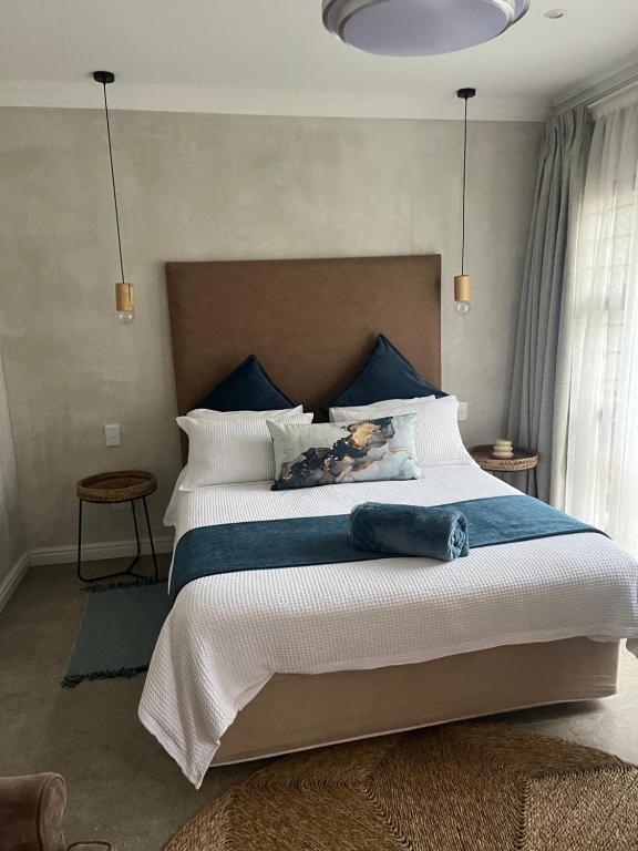 a bedroom with a large white bed with blue accents at Annie's Place in Kempton Park