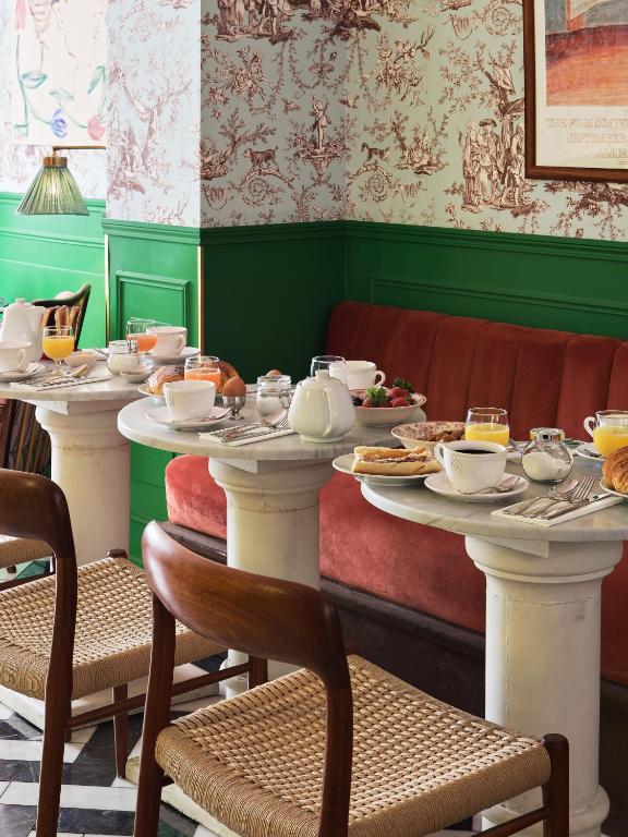 een eetkamer met twee tafels met gerechten erop bij Hôtel Les Deux Gares in Parijs