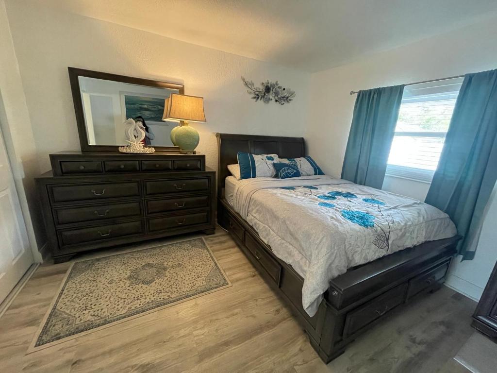 a bedroom with a bed with a dresser and a mirror at Bright and Beachy 2Bed 1Bath Home - Unit 210 in Cocoa Beach