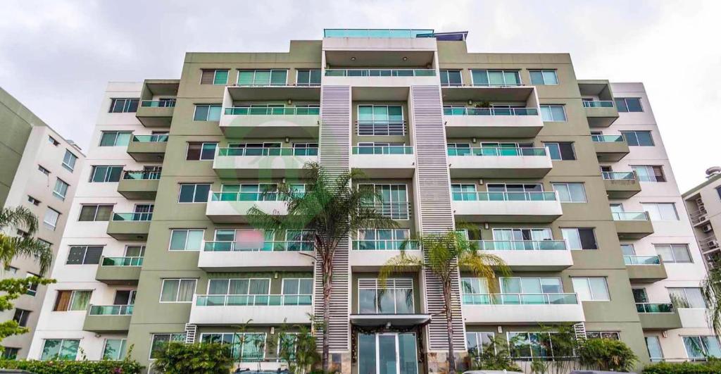 un edificio alto con una palmera delante de él en Luxury Suite, en Guayaquil