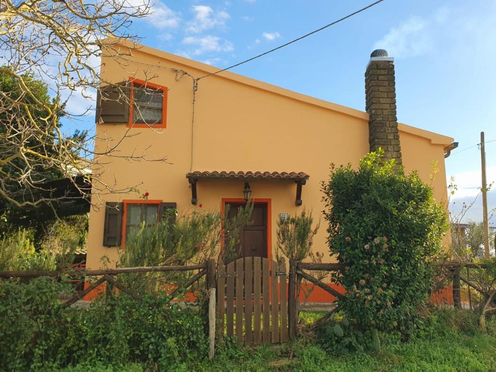a yellow house with a fence in front of it at Casa Gnigni in Sorano