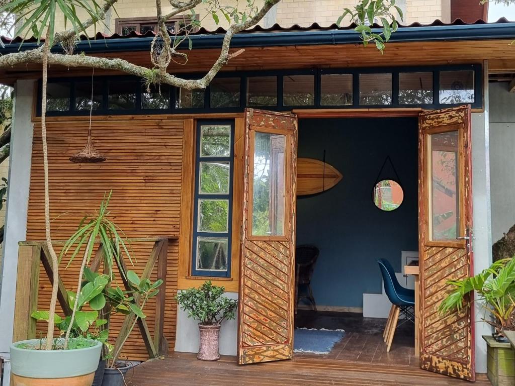 una puerta abierta de una casa con plantas en CASA DE CHICO - Tiny House, en Guarda do Embaú