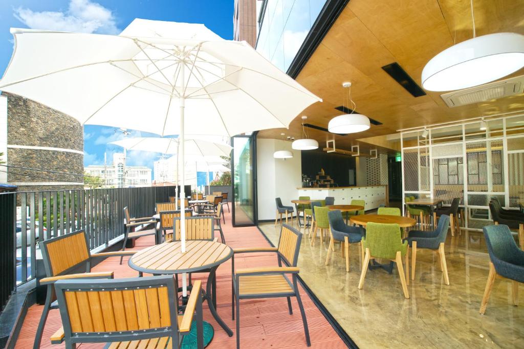 um restaurante com mesas e cadeiras e um guarda-sol em I-Jin Hotel em Jeju