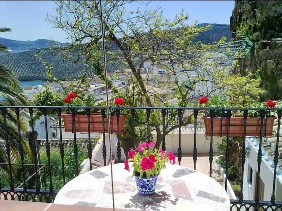 una mesa con un jarrón de flores en el balcón en La Villa, Alojamiento Rural en Iznájar