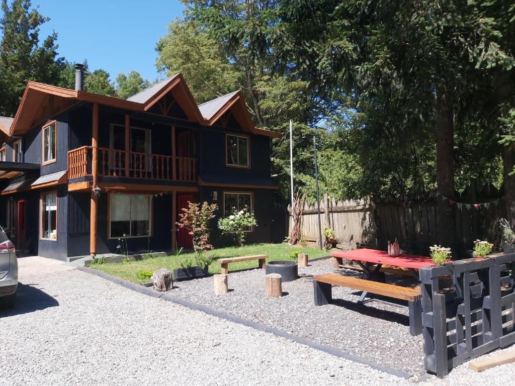 a house with a picnic table in front of it at Hostal Ruka Lodge in Villarrica