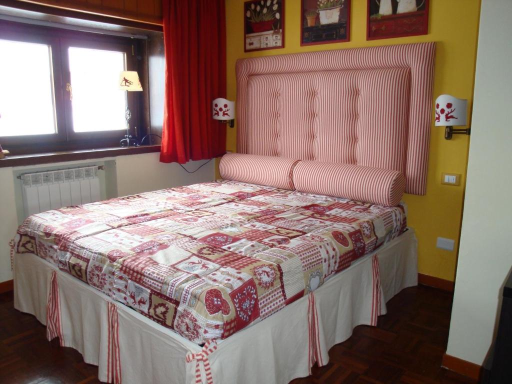 ロッカラーゾにあるAppartamento Roccaraso Aremognaのベッドルーム1室(ピンクのヘッドボード付きのベッド1台付)