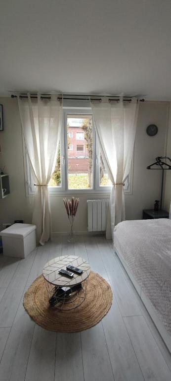 - une chambre avec un lit et une table basse dans l'établissement joli studio centre ville d'Amiens, à Amiens