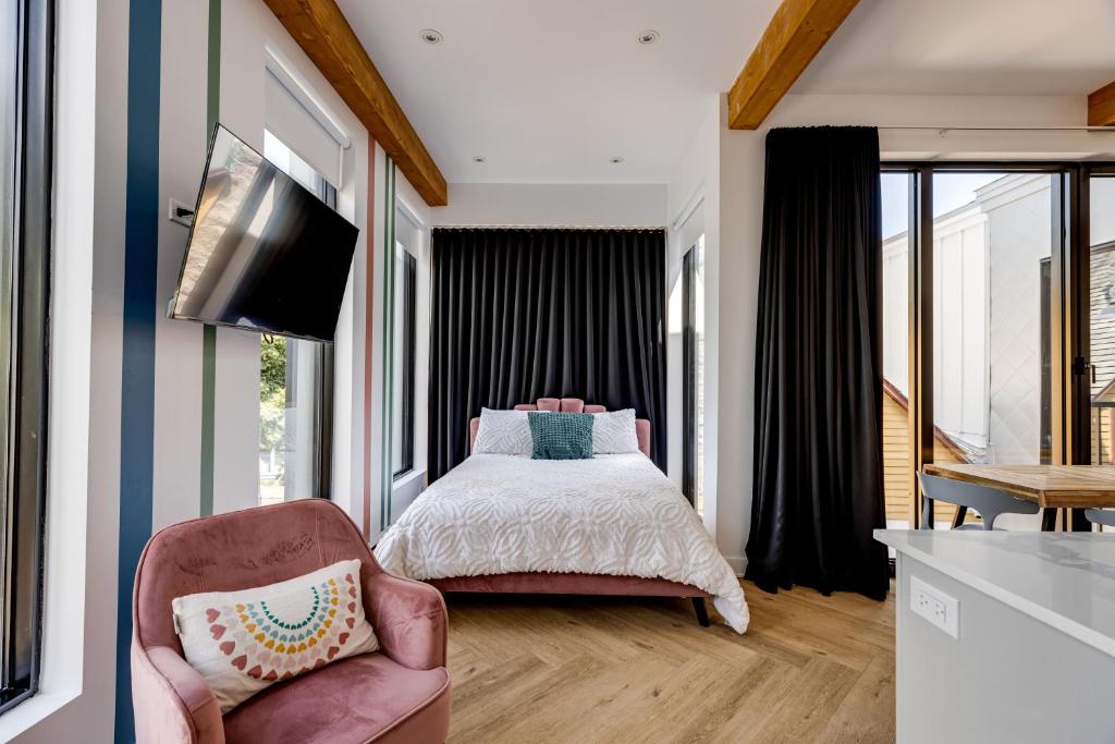 Schlafzimmer mit einem Bett und einem Flachbild-TV in der Unterkunft Le Virtuose - Vieux-Terrebonne in Terrebonne