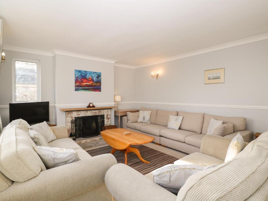 a living room with couches and a fireplace at Ambleside in Chard