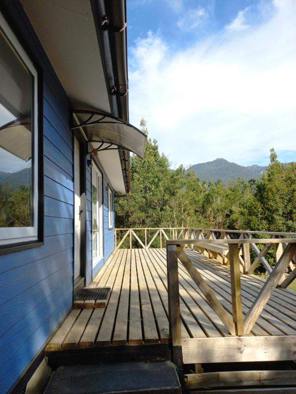 a wooden porch of a house with a view of the mountains at Tukawe in Cochamó