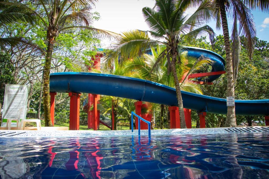 un tobogán de agua azul en una piscina con palmeras en Hotel Lagotours en San Jerónimo