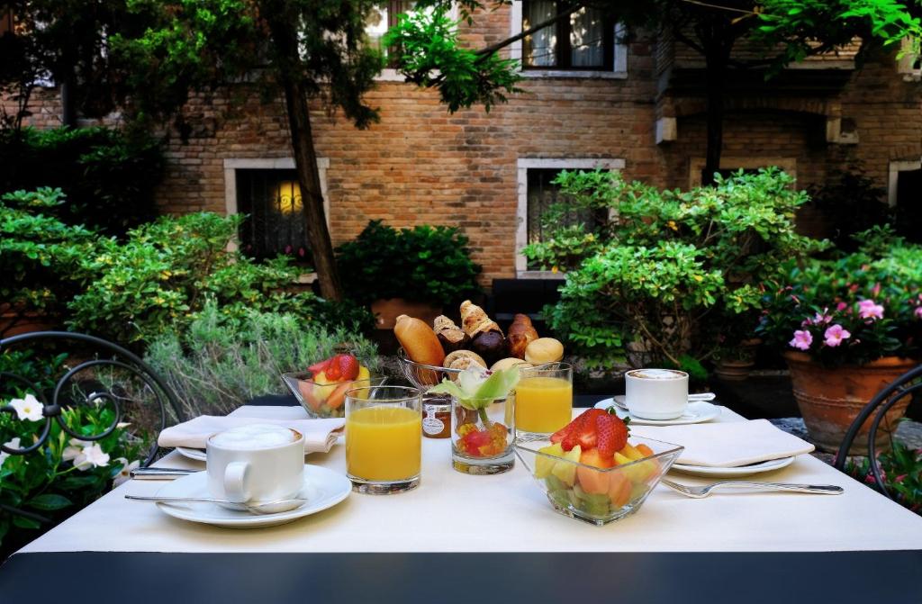 a table with fruit and juice on a table at Sina Palazzo Sant'Angelo in Venice