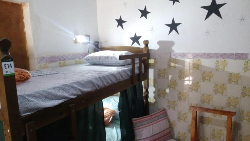 a bedroom with a bunk bed with stars on the wall at Poços Hostel in Poços de Caldas