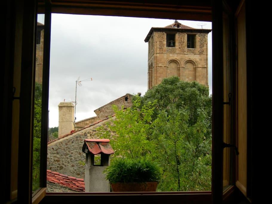 una ventana con vistas a un edificio con una torre de reloj en Apartamento Rural en Sotosalbos, en Sotosalbos