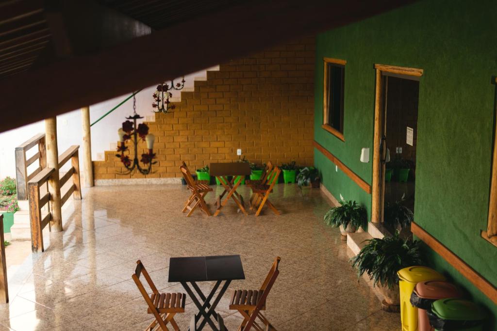 Pousada Bela Vista do Ismail - Lapinha da Serra في سانتانا دي رياتشو: غرفة بها كراسي وطاولة وجدار أخضر
