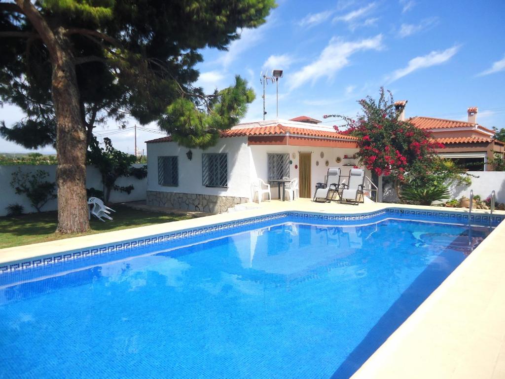 a villa with a swimming pool in front of a house at El Trosset in Peñíscola