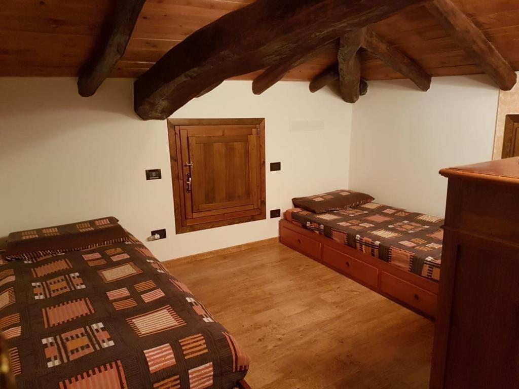 1 Schlafzimmer mit 2 Betten und einer Tür in der Unterkunft La Teggia in Monte San Pietro