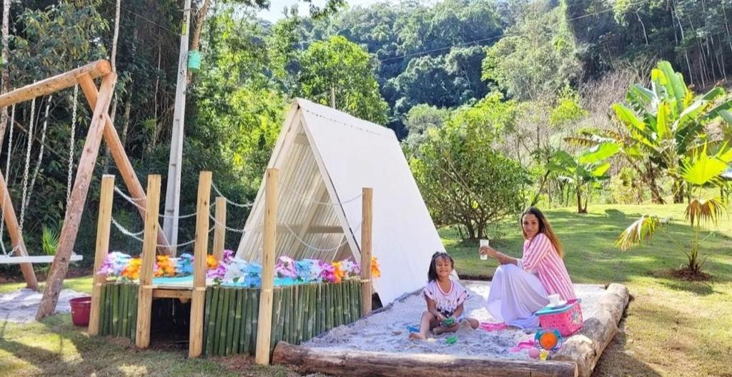 Kobieta i dziewczynka siedzące na namiocie zabaw w obiekcie Cabana A frame Paraíso nas Montanhas w mieście Marechal Floriano