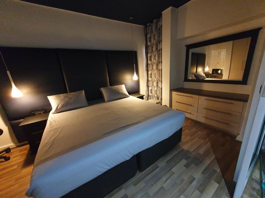 1 dormitorio con 1 cama grande y espejo grande en Unit 26, Genesis, en Johannesburgo