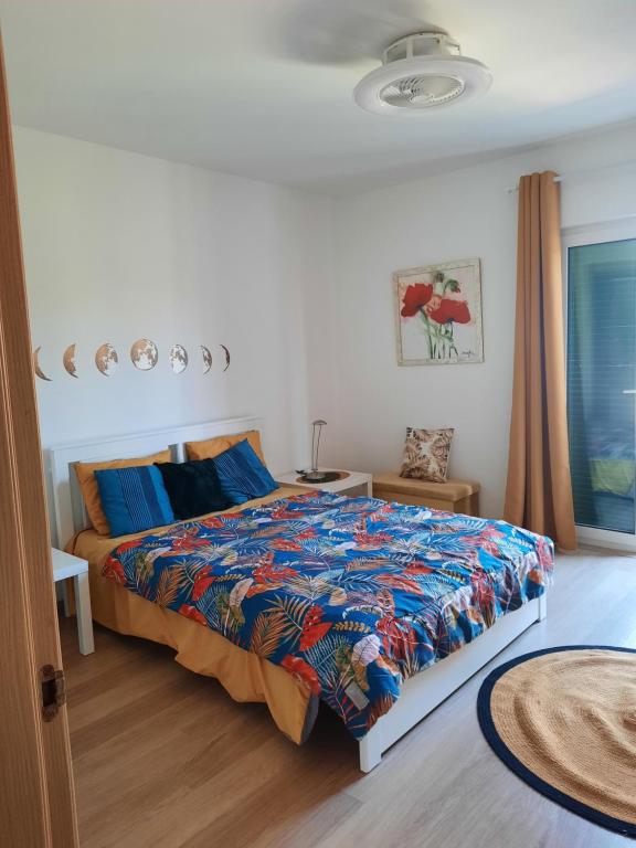 una camera da letto con un letto con un piumone colorato di vila verde twonhouse T54 a Santa Maria