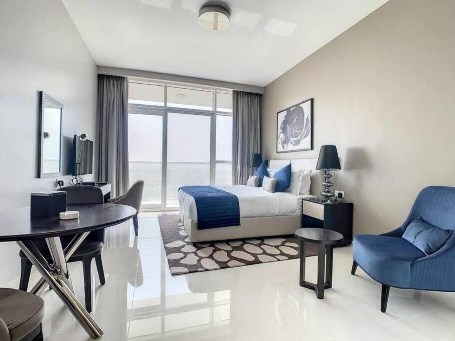 sypialnia z łóżkiem, stołem i krzesłami w obiekcie Brand New Studio in Artesia in Damac Hills w Dubaju