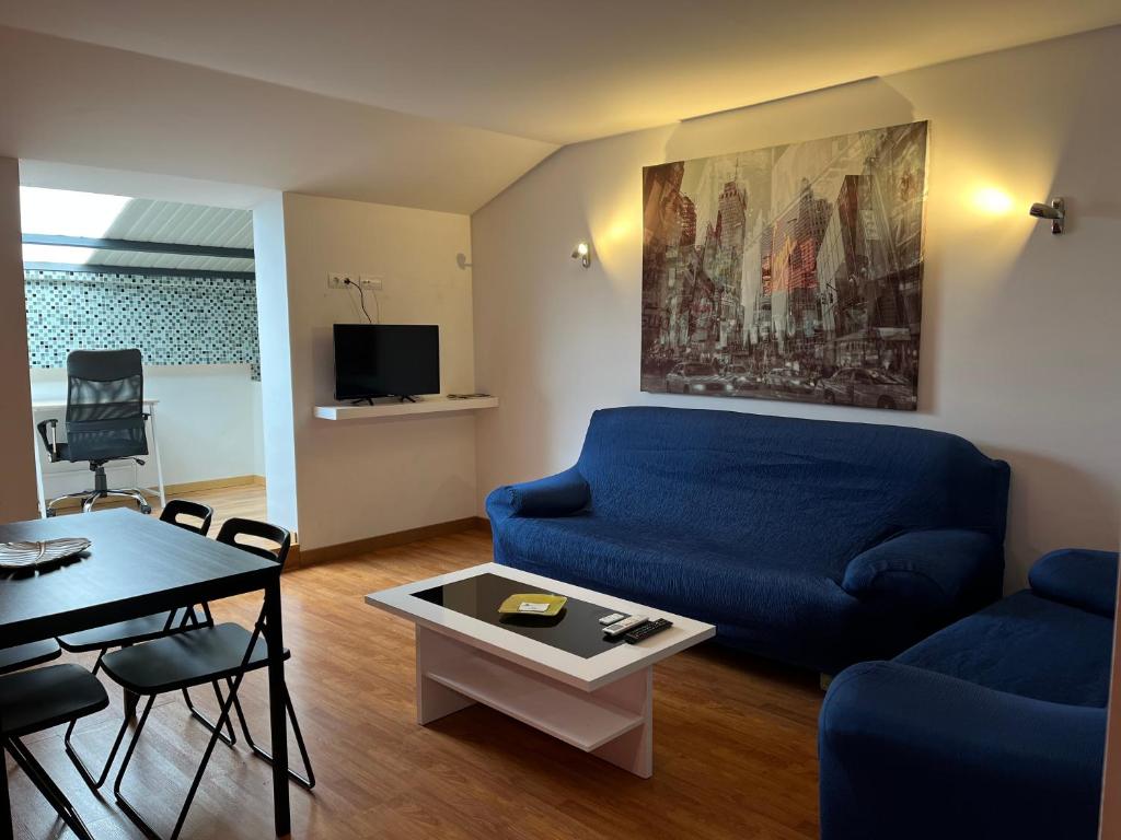 - un salon avec un canapé bleu et une table dans l'établissement Lagunas Ruidera 16 Agua y Placer, à Ruidera
