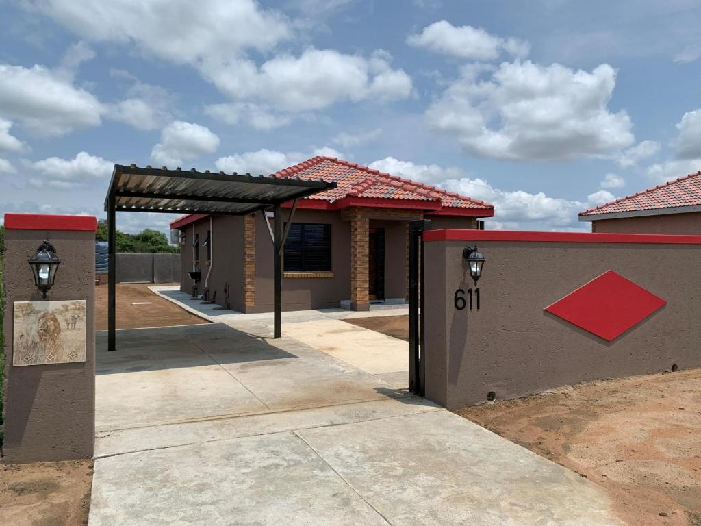 a building with a garage with a sign on it at Lion House, 3 bedroom House next to Pilanesberg and Sun City in Mogwase