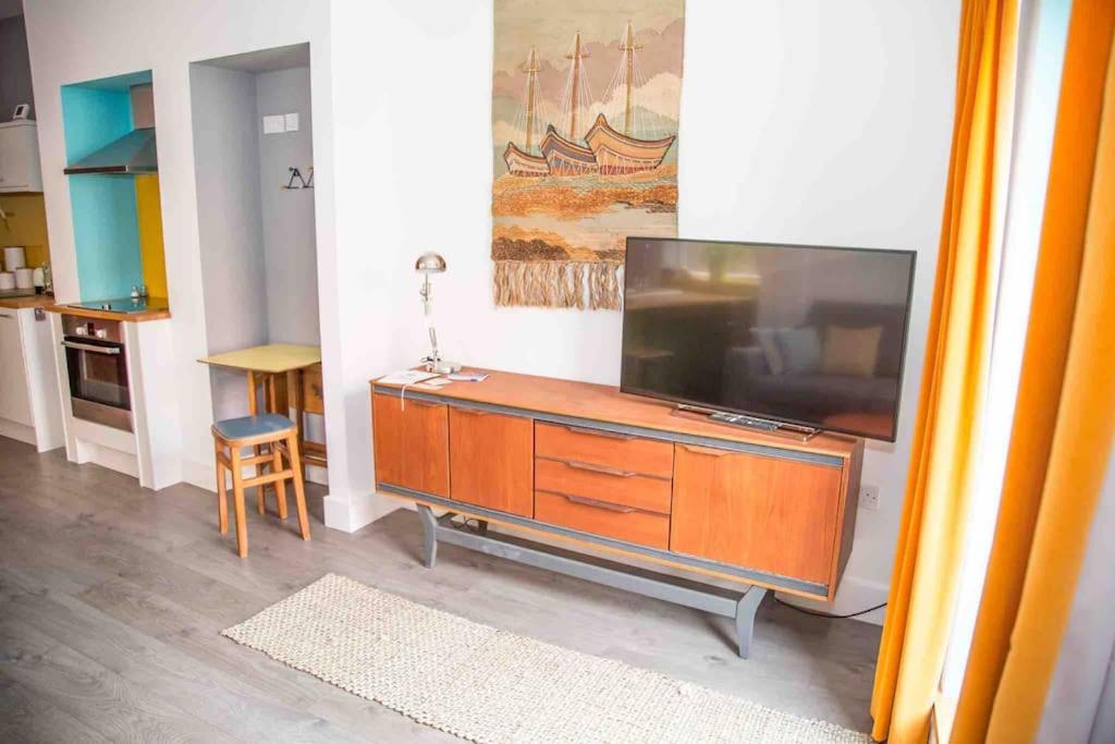 una sala de estar con TV de pantalla plana en una cómoda en Chequer - seafront 1 bed ground floor garden flat en Cleethorpes