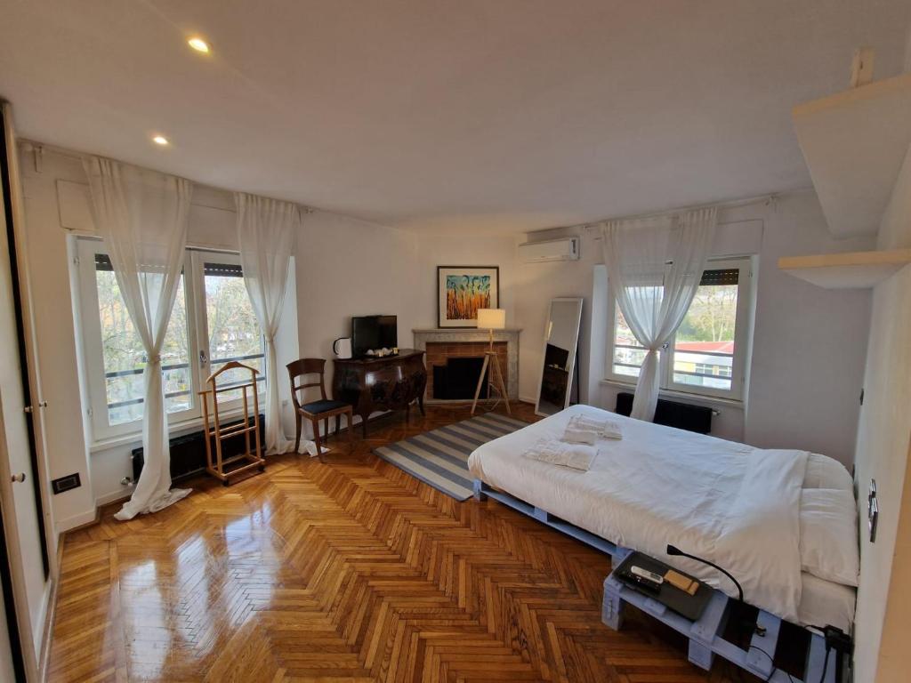 a bedroom with a bed and a desk and windows at ELEGANT ROOMS PARIOLI in Rome