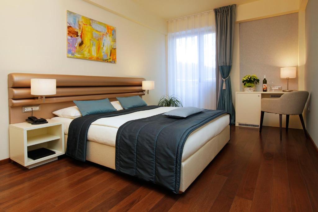 a bedroom with a bed and a dresser at Hotel Korkyra in Vela Luka