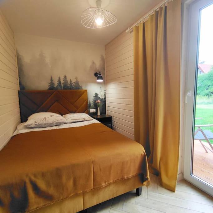 Posteľ alebo postele v izbe v ubytovaní Ślusarnia-domek z sauną nad jeziorem, Kaszuby