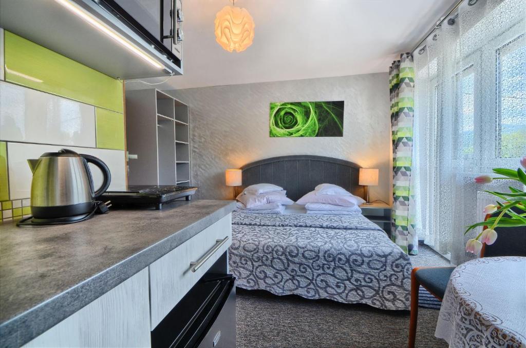 a hotel room with a bed and a kitchen at Willa Cyprys - pokoje i apartamenty z aneksami - Centrum in Wisła